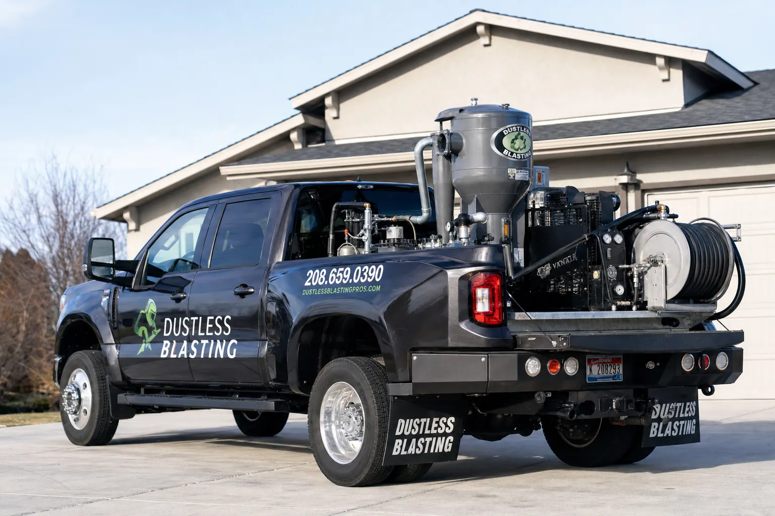 Mobile dustless blasting rig — pickup truck equipped with blast pot and compressor parked on a driveway
